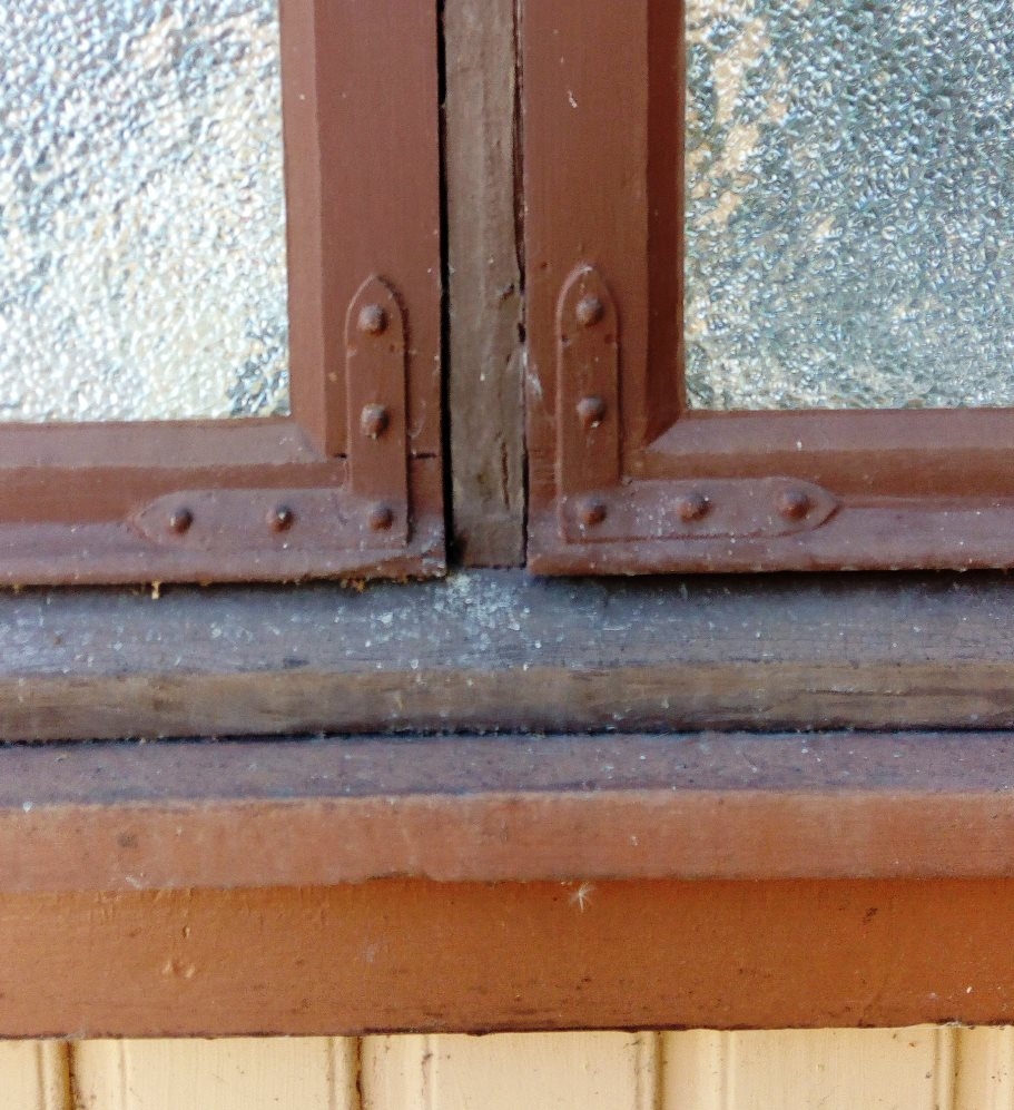 Originalt hjørnejern bøyet til på den påmonterte fallisten på vindusrammen. Krøderen i Buskerud, sent 1800- tallet. Foto: Gamletrehus.no